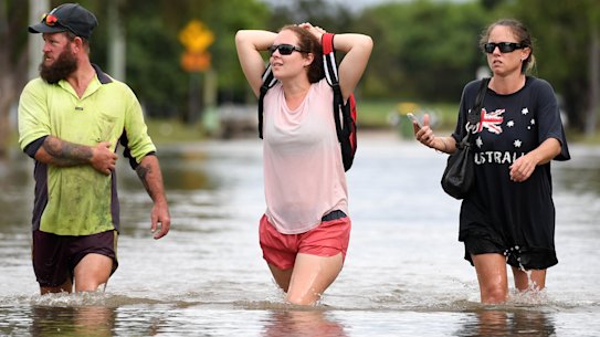 Local residents wade through flood water  in Townsville, Queensland, in February this year.