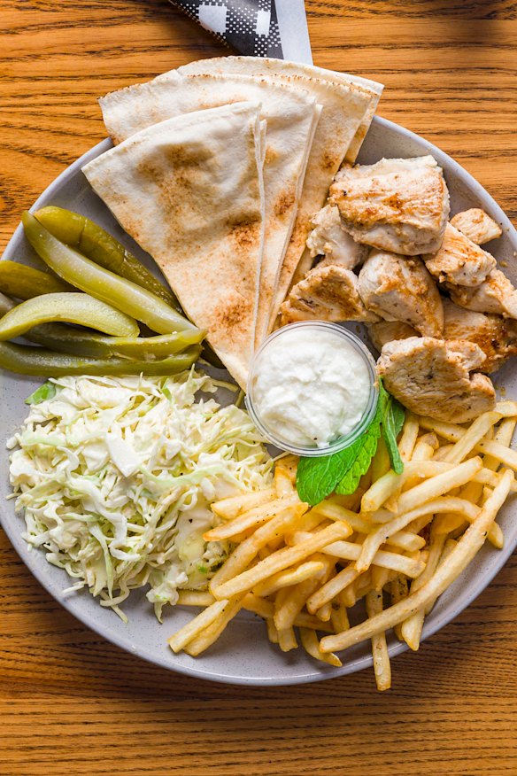 Grab marinated chicken with a side of fries, pita and pickles.