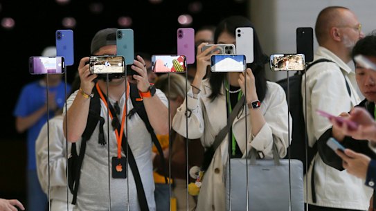 Attendees take a closer look at the Apple iPhone 16 after its announcement.