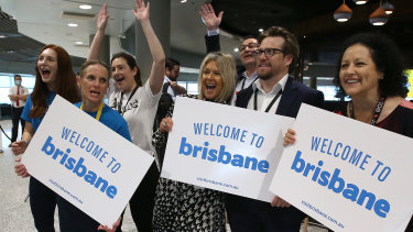 Brisbane Airport staff greet the first passengers to arrive from Sydney since the Queensland borders reopened.