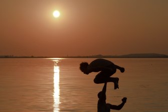 A man jumps into a lake in Bucharest, Romania during a heatwave in July 2015: global temperatures are now about 1.1 degrees warmer than the pre-industrial era and are on track to be more than 3 degrees warmer by the end of this century if carbon emissions are not curbed, the World Meteorological Organisation warns.