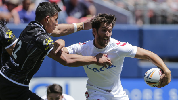 Breaking new ground: Canberra and New Zealand back-rower Joe Tapine (left) tackles England's Stefan Ratchford in Denver in June.