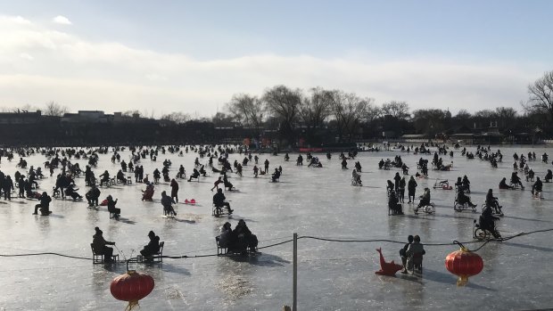 Beijingers enjoy a very different kind of ice skating on a frozen lake behind the Forbidden City. 
