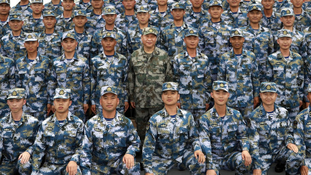 Chinese President Xi Jinping poses with soldiers on a navy ship after he reviewed the Chinese People's Liberation Army Navy fleet in the South China Sea.