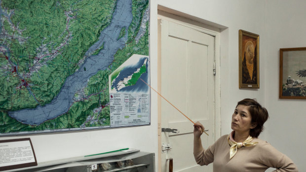 Yulia Mushinskaya, the director of the local museum in Khuzhir on Olkhon Island, Russia, with a map of Lake Baikal.