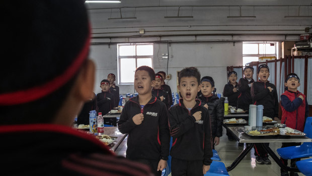 Students at the Real Boys Club in Beijing recite the club's pledge.