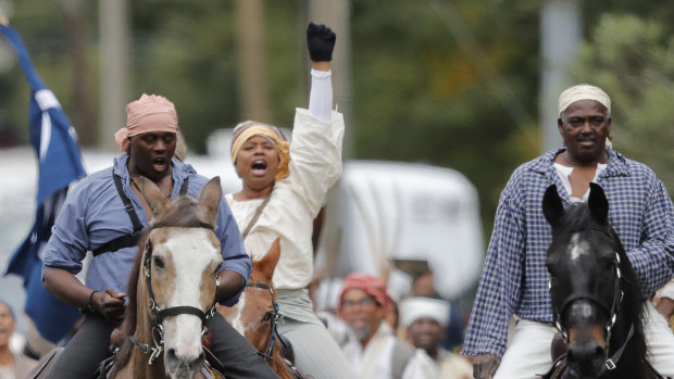 People participate in a performance artwork reenacting the largest slave rebellion in US history in LaPlace, Louisiana.