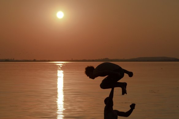 A man jumps into a lake in Bucharest, Romania during a heatwave in July 2015: global temperatures are now about 1.1 degrees warmer than the pre-industrial era and are on track to be more than 3 degrees warmer by the end of this century if carbon emissions are not curbed, the World Meteorological Organisation warns.