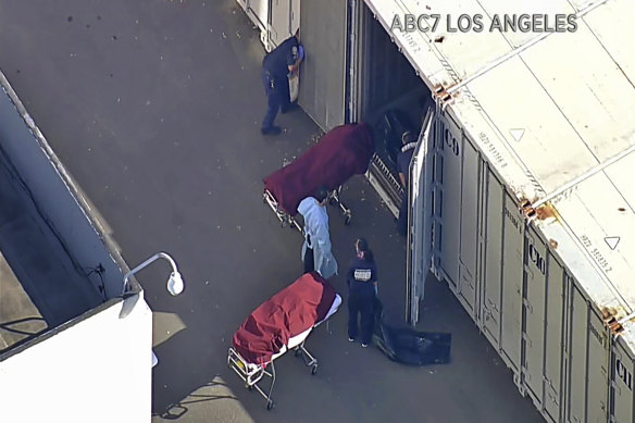 Workers put bodies into a refrigerated trailer at the offices of the Los Angeles County Coroner this month.
