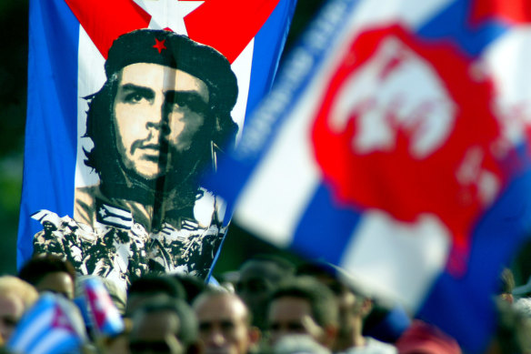 Cubans hold a poster of Ernesto “Che” Guevara  during a Havana demonstration, 2003.