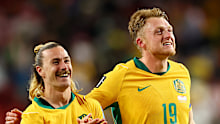 Jackson Irvine #22 and Harry Souttar #19 of Australia celebrate after a 0-0 draw.