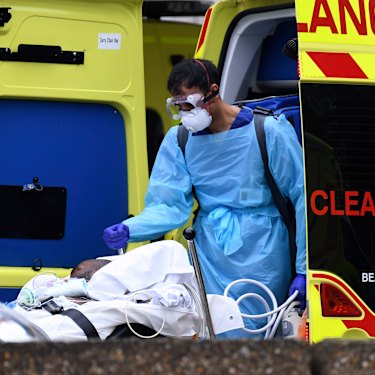 A patient is taken from an ambulance outside St Thomas' Hospital in London.