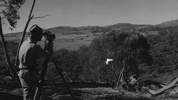 Assistant Survey Chief Harry Stacey takes level readings at Adaminaby Dam site. 