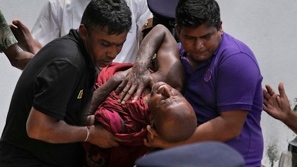 An injured Sri Lankan Buddhist monk is carried away after being injured in anti-government protests.