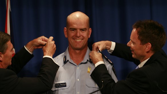 Then-premier John Brumby (left) and police minister Bob Cameron with newly appointed police chief Simon Overland in 2009.