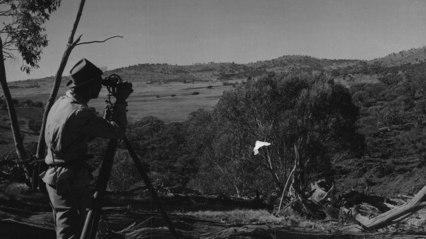 Assistant Survey Chief Harry Stacey takes level readings at Adaminaby Dam site. 