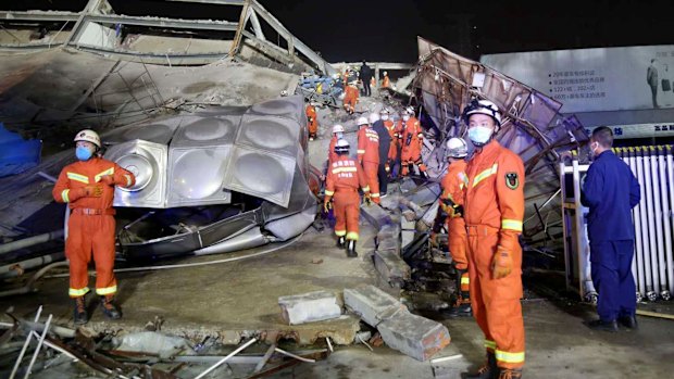 Rescuers work at the site of a collapsed five-story hotel building in Quanzhou city in southeast China's Fujian province. 