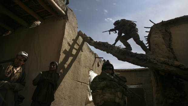 Australian soldiers search a house for weapons, explosives and Taliban fighters during a foot patrol in Chora, Afghanistan, in 2009.