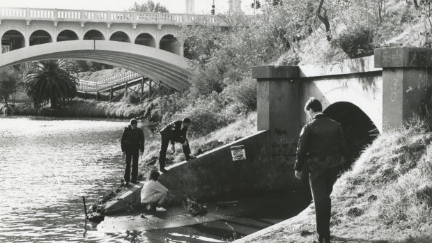 Police check a storm water drain on the banks of the Yarra River near the scene of the shooting.