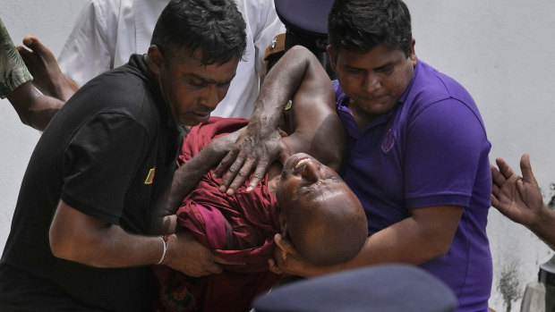 An injured Sri Lankan Buddhist monk is carried away after being injured in anti-government protests.