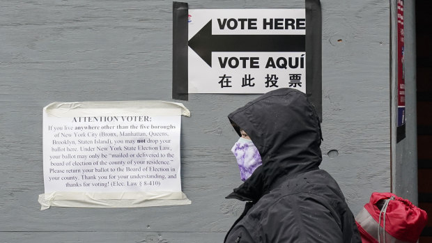 A woman wears a protective mask during the coronavirus pandemic as she stands in line for an early voting location near Lincoln Centre in New York. 