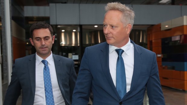 Celebrity financial planner Sam Henderson, right, leaves the Federal Court.