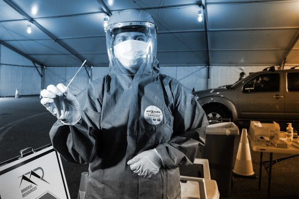 A nurse at a drive-through clinic for miners in Perth. All fly-in, fly-out workers must be tested 24 hours before takeoff to their work site.