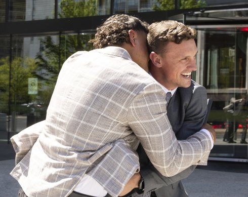 Latrell Mitchell and Jack Wighton embrace after addressing the media outside the ACT Magistrates Court.