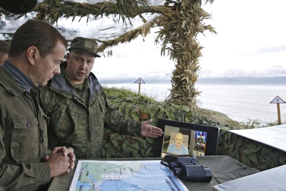 Dmitry Medvedev (left) visits a military outpost on Iturup Island in 2015 when he was prime minister.
