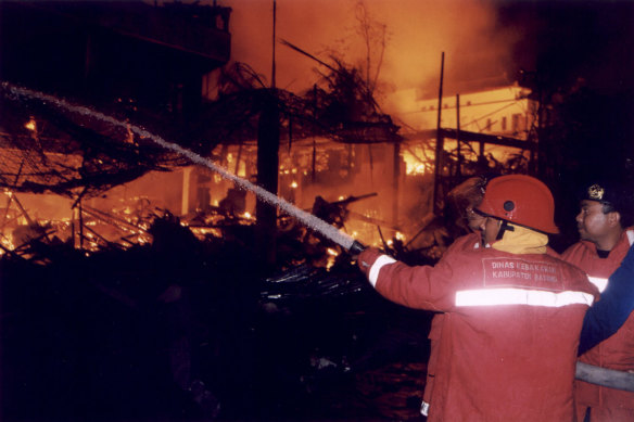 Firefighters attempting to extinguish the blaze ignited by the blast at the Sari Club, early Sunday morning October 13, 2002. 