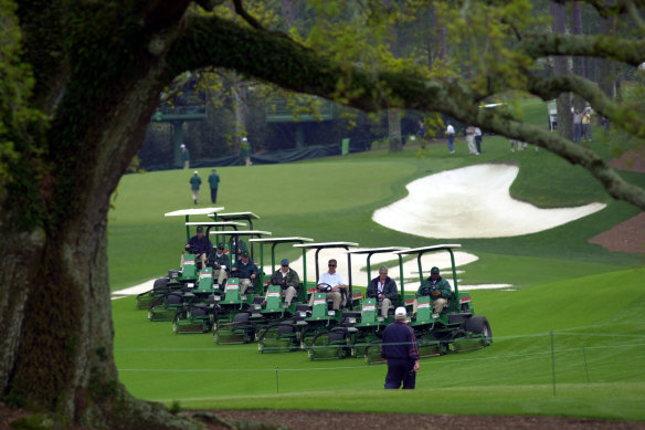 Grounds crews mow along the 10th fairway at the Augusta National Golf Club.