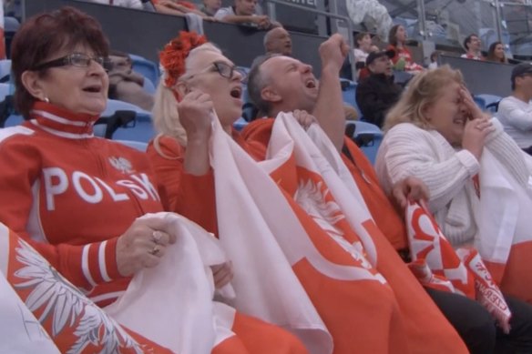 Polish fans react after an extraordinary parry from Frances Tiafoe.