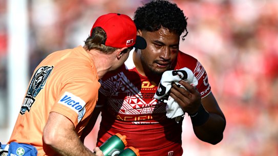Eli Katoa is helped from the field after a head knock while playing for Tonga.
