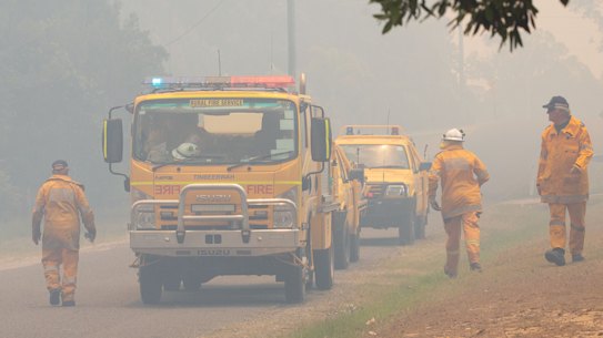 Firefighters are seen near fires at Lake Cooroibah Road and Jirrimah Crescent in Cooroibah on Saturday.