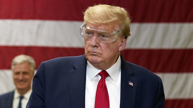 US President Donald Trump, wearing safety glasses but no mask, tours a factory making face masks in Phoenix, Arizona. 