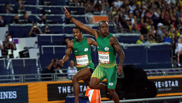 Akani Simbine of South Africa (right, gold) and Henricho Bruintjies of South Africa (at left, rear, silver) celebrate their respective medals.