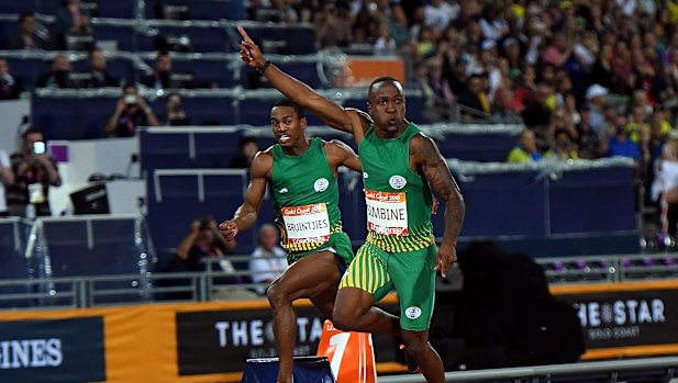 Akani Simbine of South Africa (right, gold) and Henricho Bruintjies of South Africa (at left, rear, silver) celebrate their respective medals.