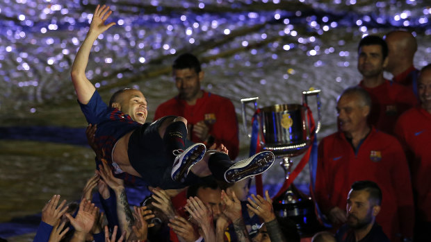 Andres Iniesta is tossed into the air by his Barcelona teammates.