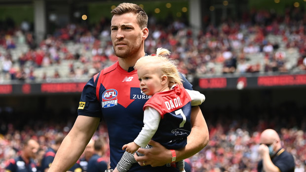 Jack Viney, holding his daughter, walks out on to the MCG as a premiership player.