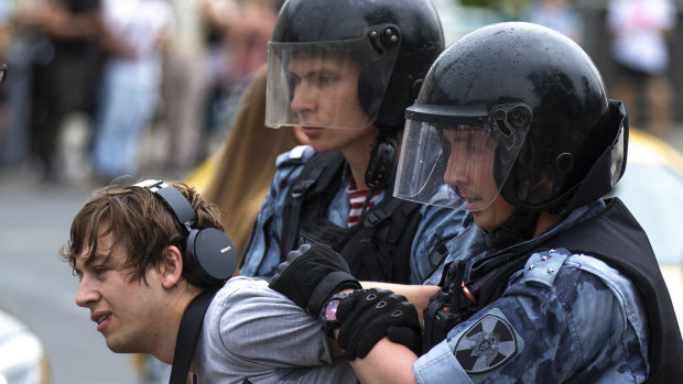 Police officers detain a protester during a march in Moscow, Russia.
