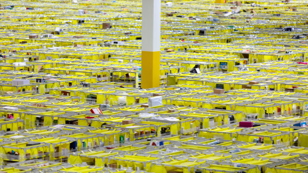 Shelves with products are organised and moved around by orange Amazon robots inside the Amazon Fulfillment Center in Carteret, New Jersey.