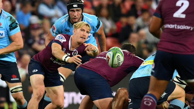 Tate McDermott of the Reds (centre) passes the ball against the Waratahs on May 18.
