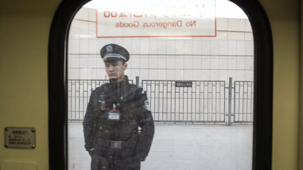A police officer is seen through a train window in Turpan, Xinjiang, last year.