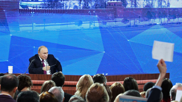 The Russian leader was addressing more than 1000 reporters from around the world, many of them holding up signs to attract his attention.