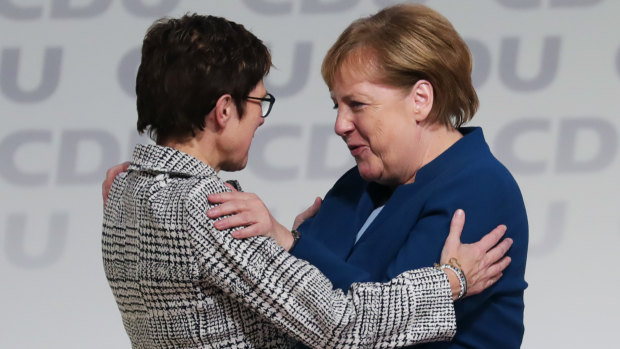 Angela Merkel (lright) congratulates Annegret Kramp-Karrenbauer on becoming the head of Germany's ruling party.