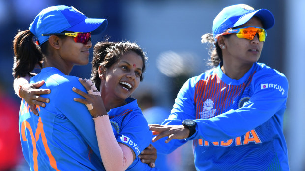 Poonam Yadav is mobbed by teammates after snaring a wicket against Sri Lanka.