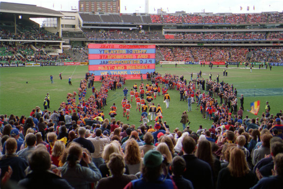 Players run onto the ground for Fitzroy's farewell game at the MCG.