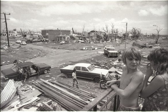 Children look on as people inspect the damage from Cyclone Tracy, which hit Darwin in 1974.