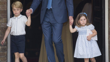 Prince George and Princess Charlotte holding onto their father Prince William's hands as they leave the chapel.