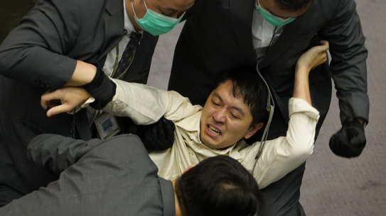 Hui is removed by security officers during scuffles between pro-establishment and opposition lawmakers in May 2020.